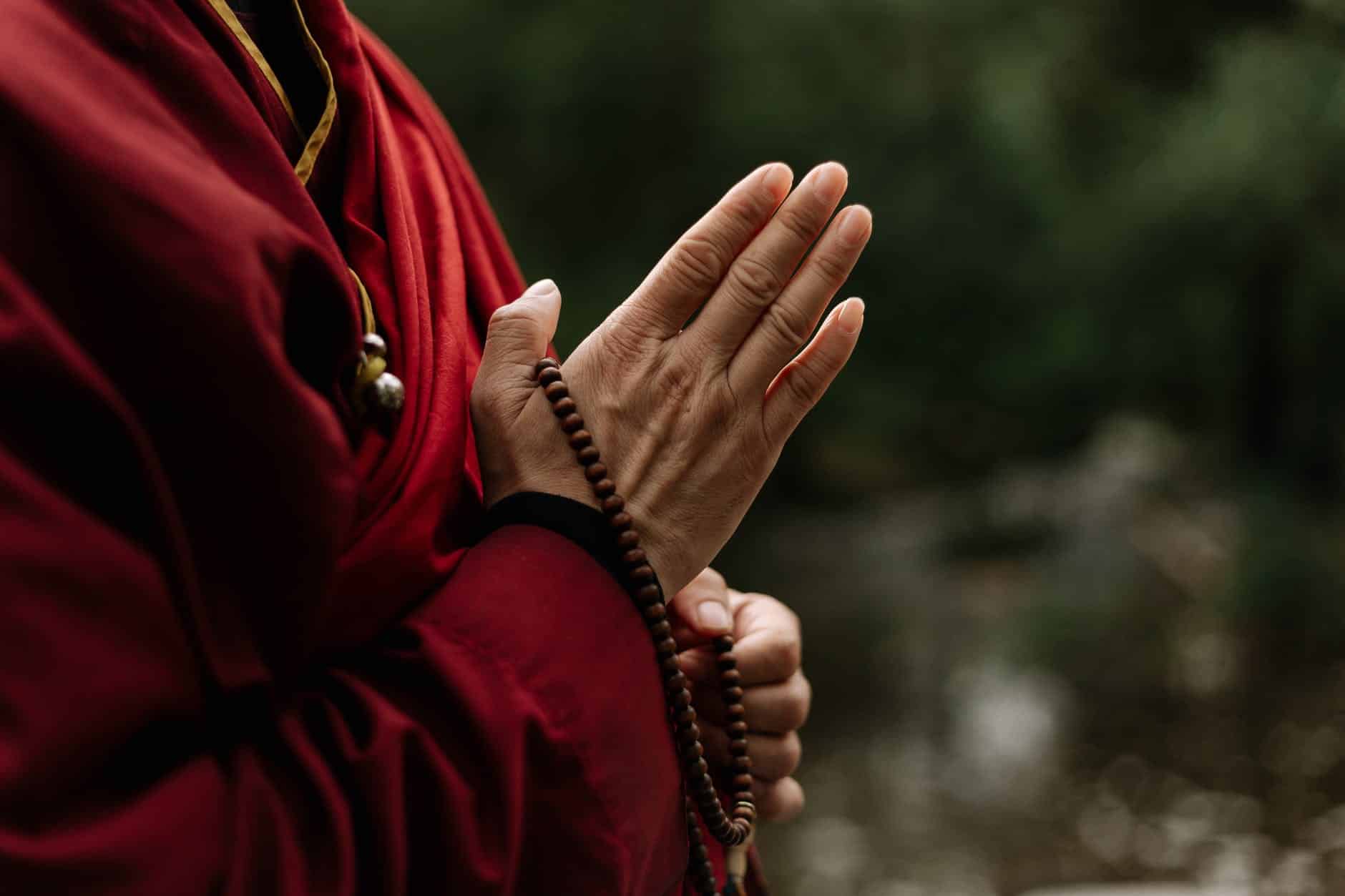 person in red long sleeve shirt wearing brown beaded bracelet